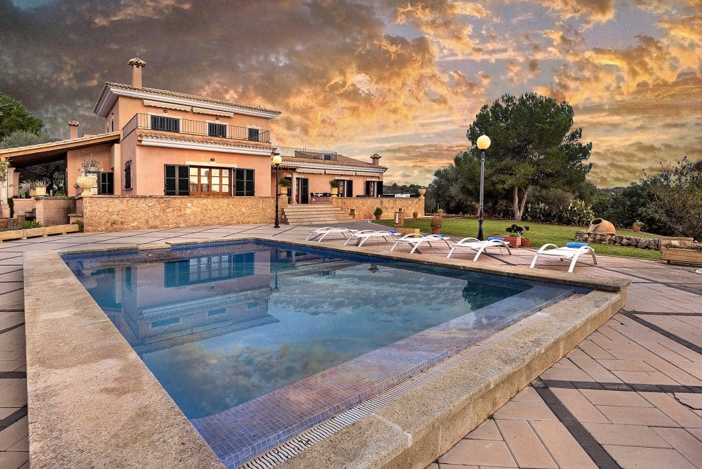 piscina exterior al atardecer en nuestra villa vacacional de lujo en Palma de Mallorca